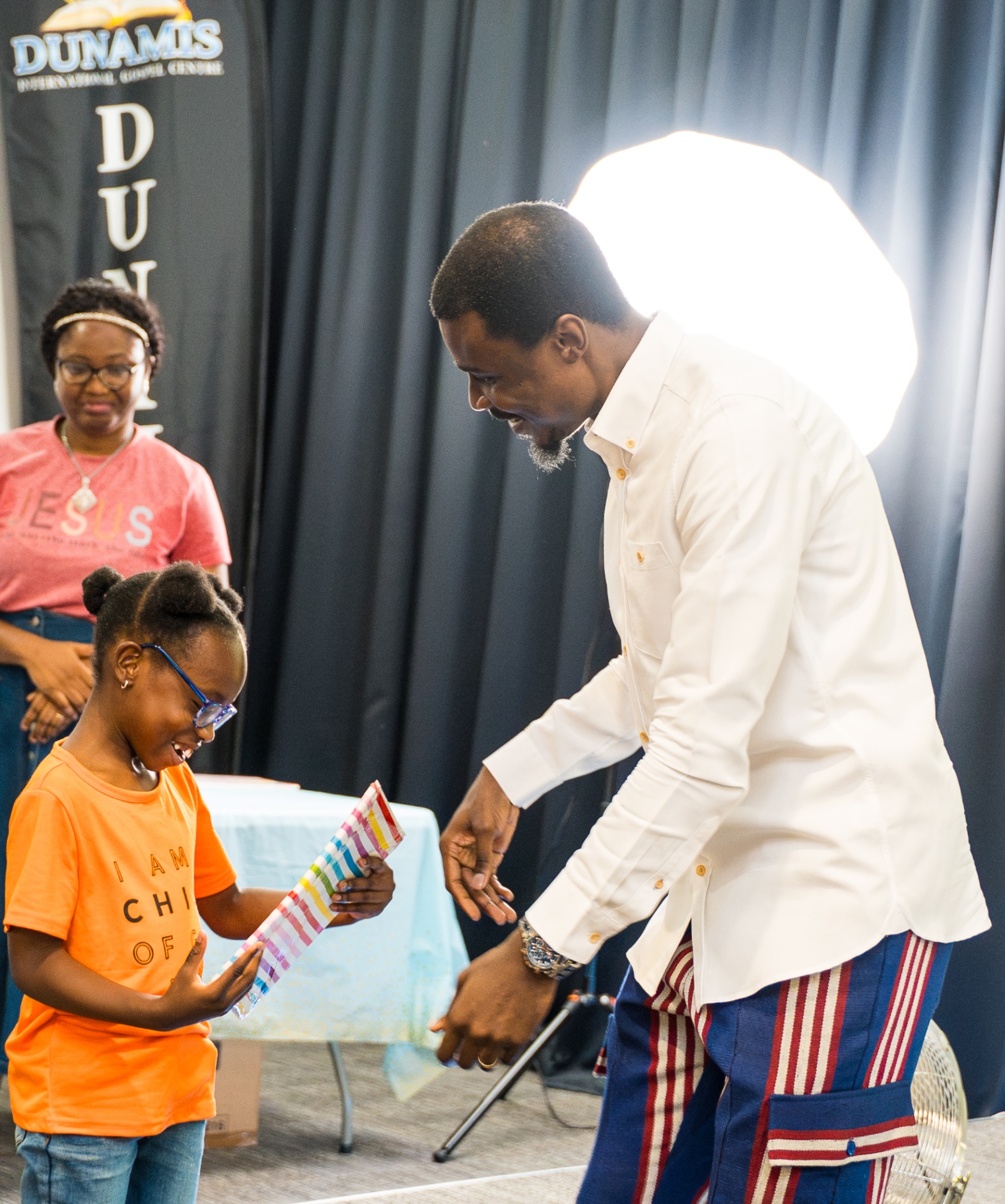 Young girl receiving recognition from a church leader