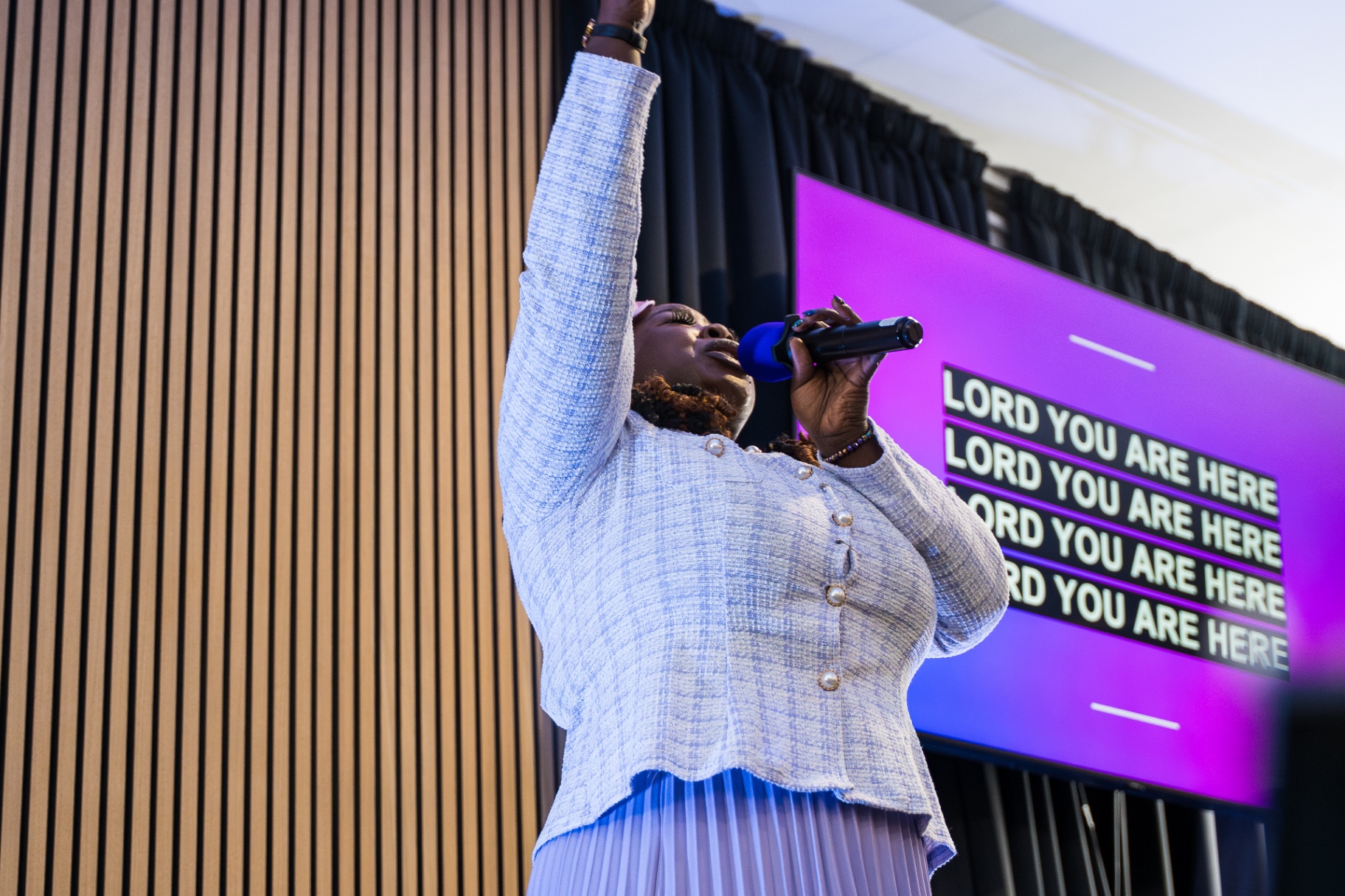 Worshipper with hand lifted high in surrender