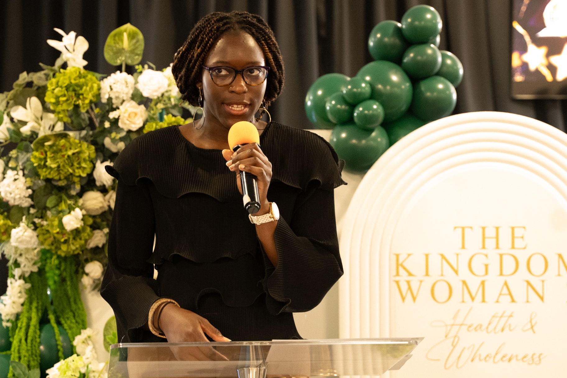 Woman speaking at The Kingdom Woman conference lectern