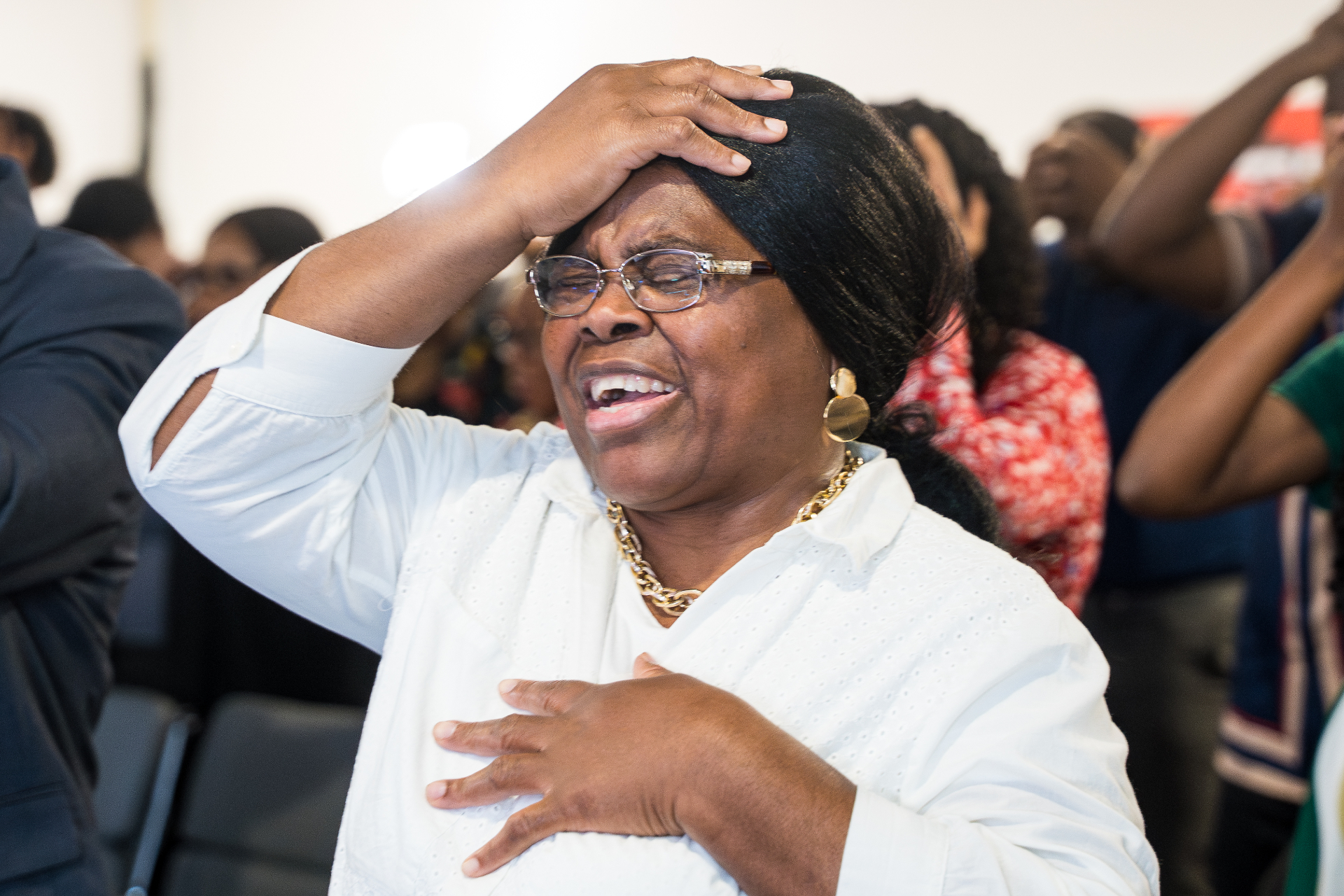 Woman in white receiving prayer during a worship service