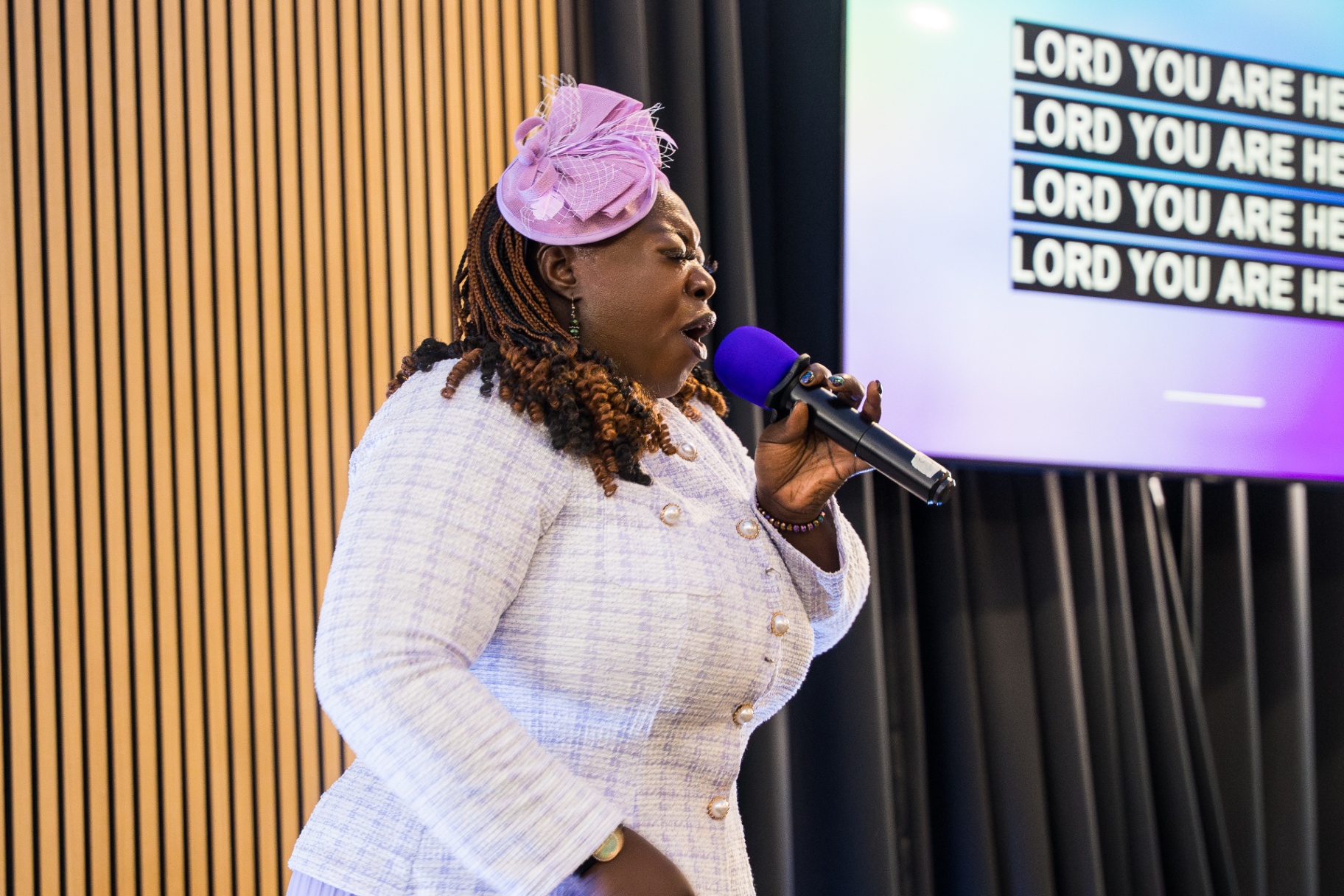 Worshipper singing with eyes closed during Lord You Are Here