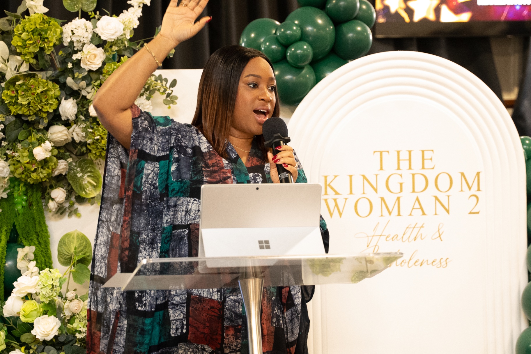Minister lifting hand in worship at The Kingdom Woman 2 conference