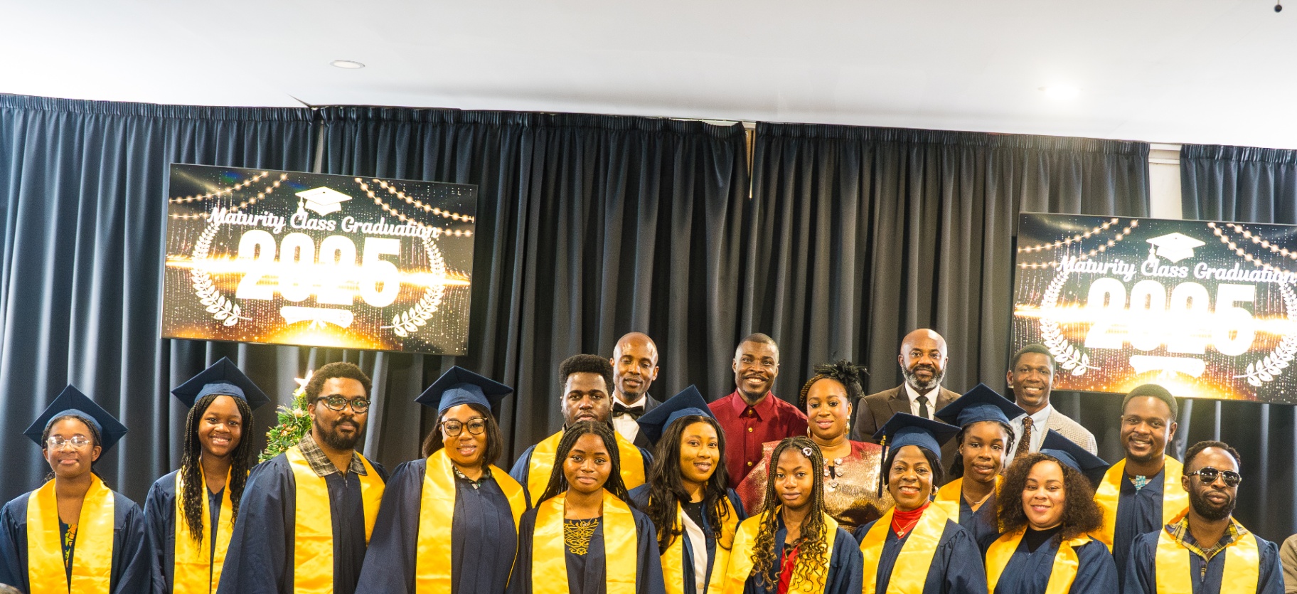 Maturity Class 2025 graduates in caps and gowns on stage