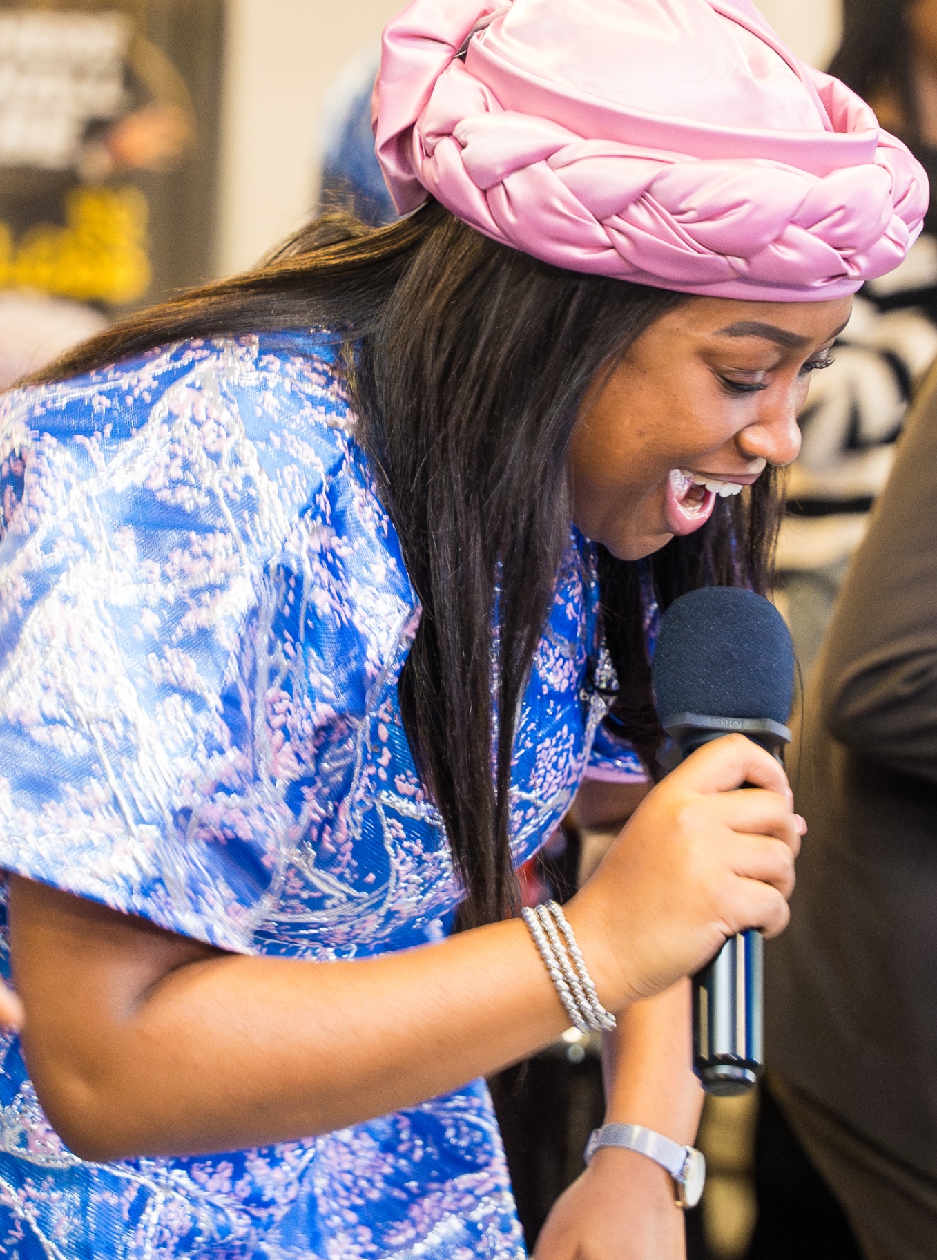 Woman smiling brightly while speaking into a microphone during service