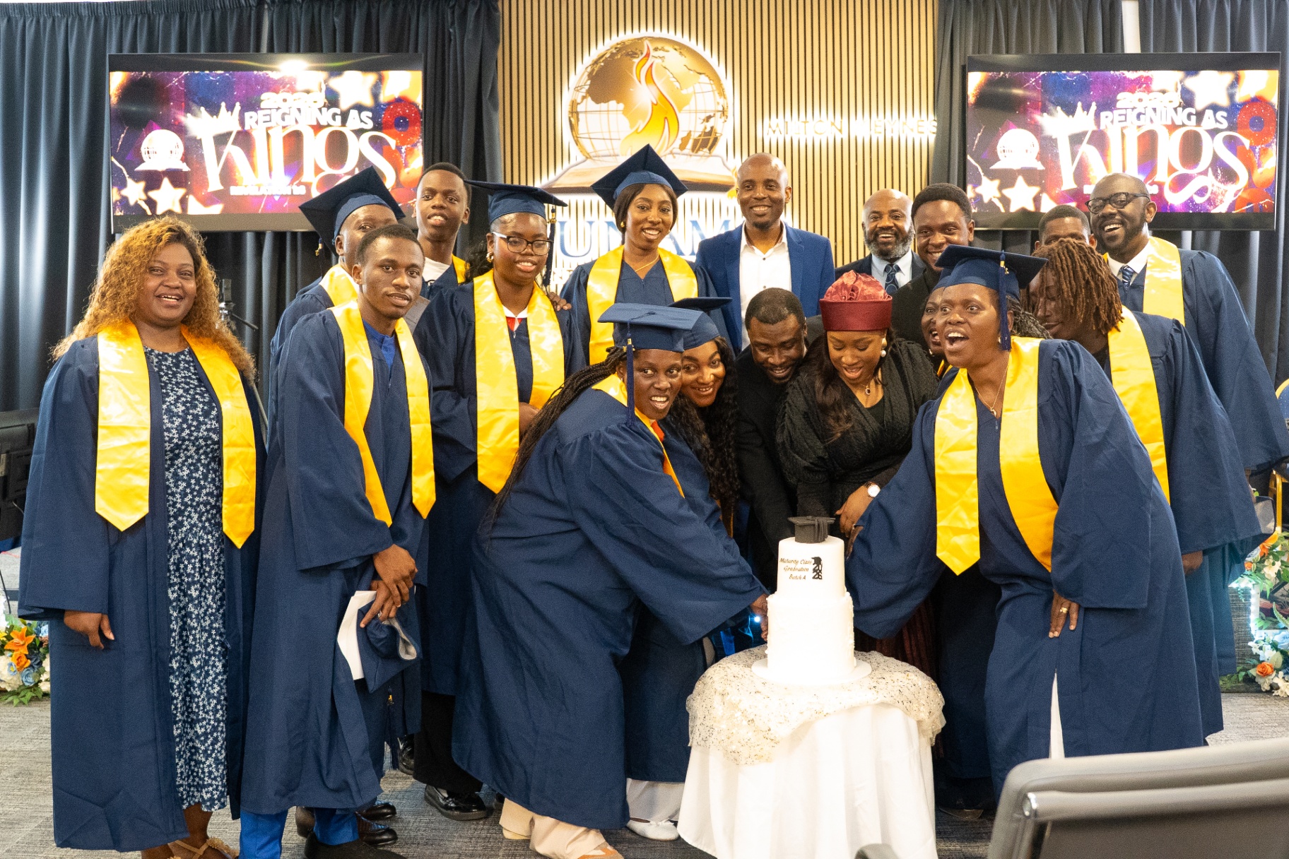 Maturity Class graduates cutting cake with senior pastors