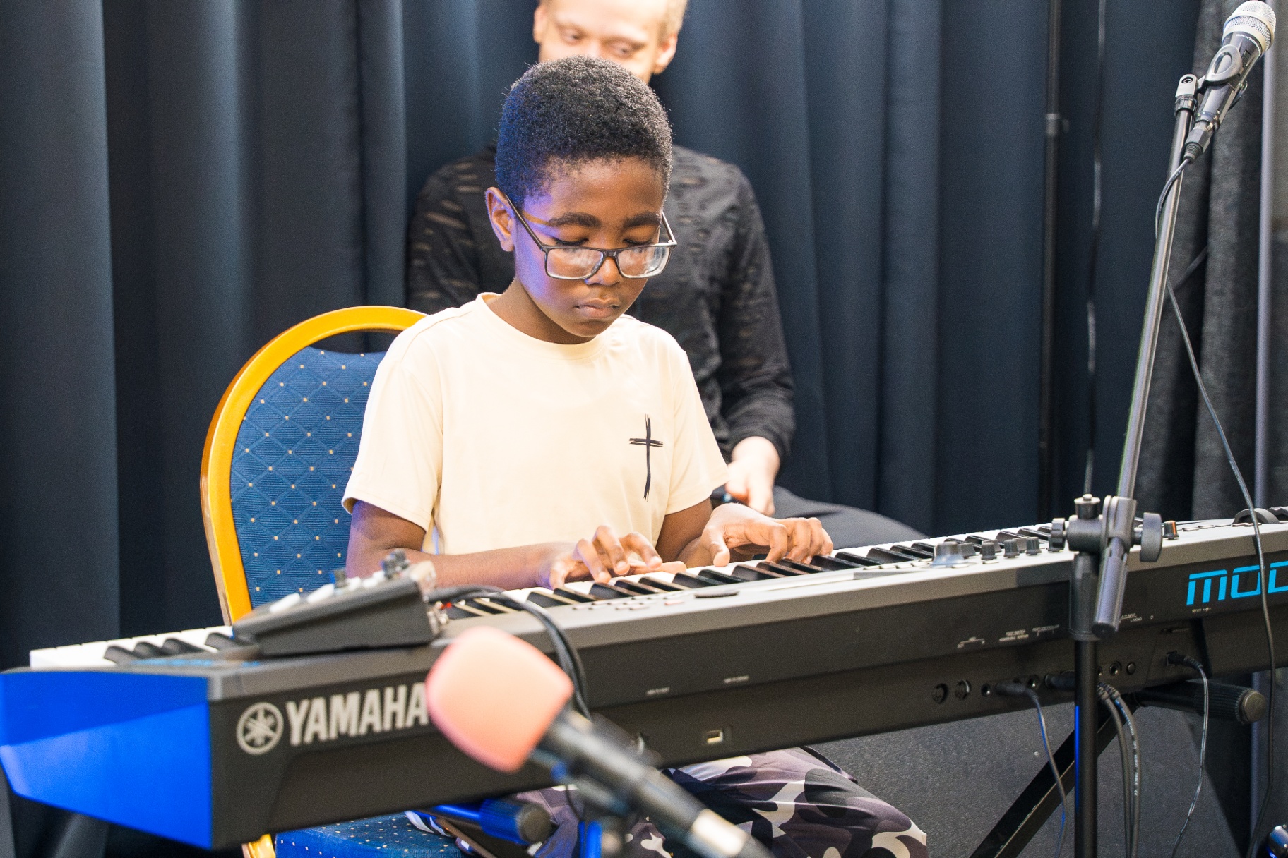 Young boy focused while playing keyboard during service
